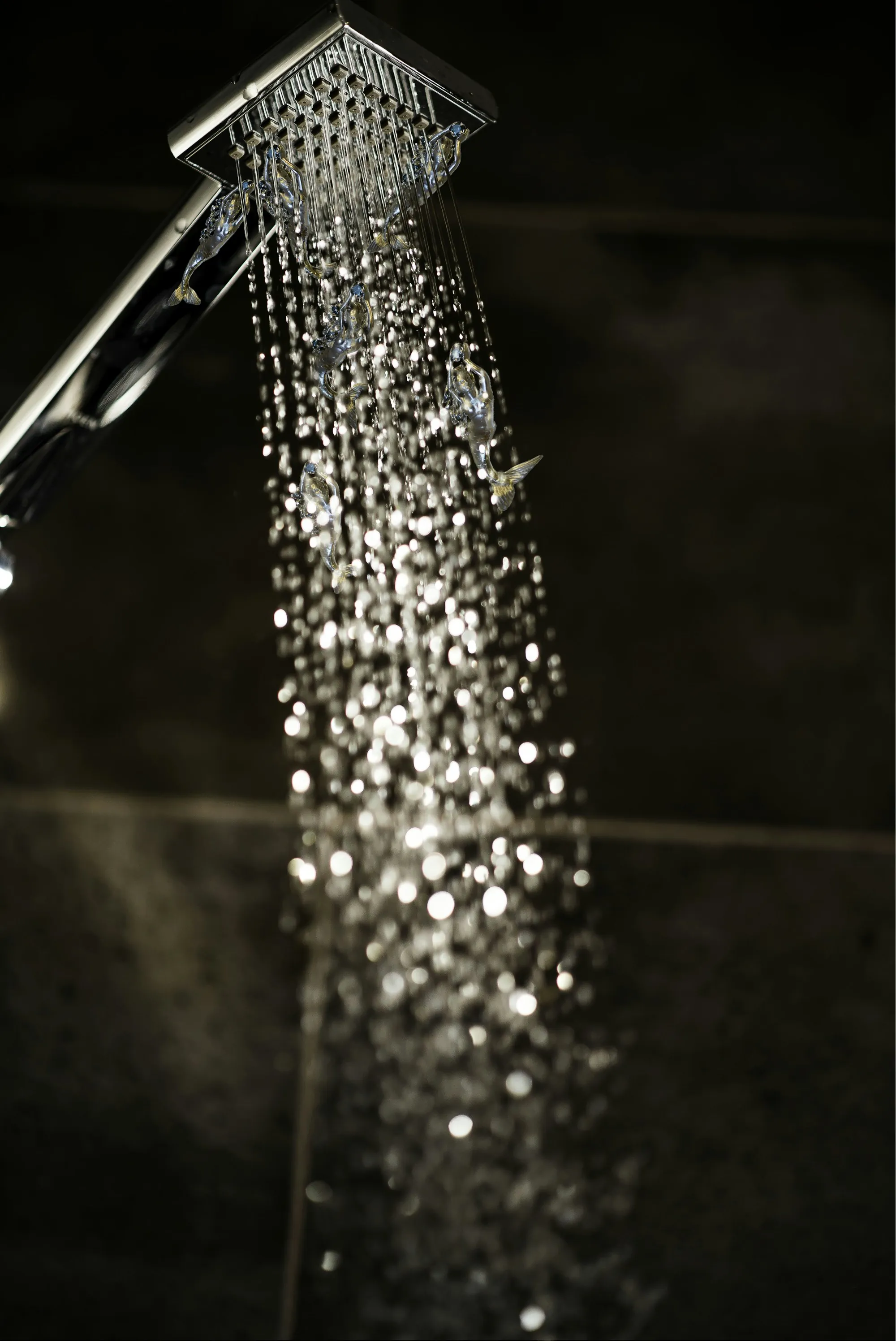 Close-up of a shower head running hot water